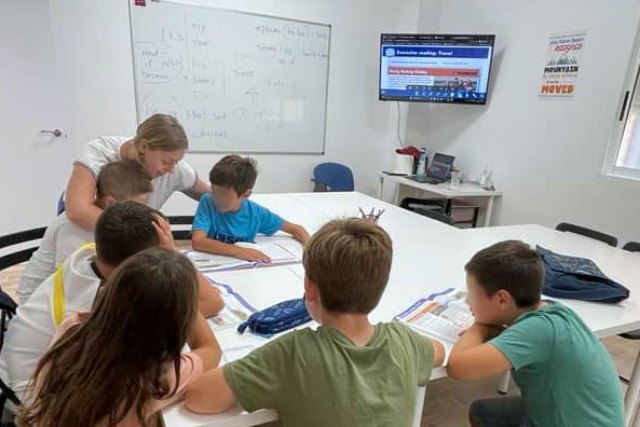 Actividad dinámica en clase de inglés para niños, con juegos educativos y participación activa